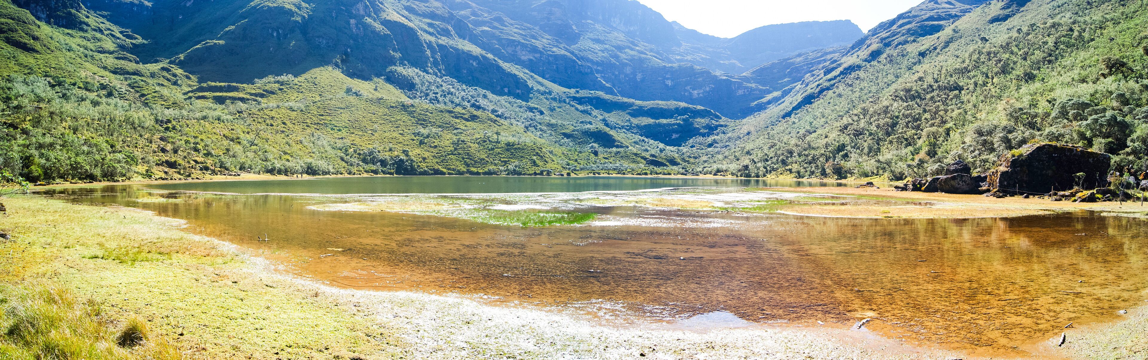 A river winding through a mountainous valley with lush greenery and rocky outcrops.