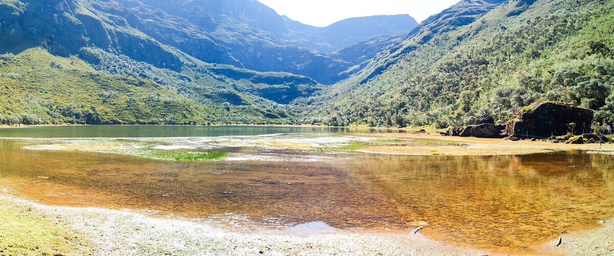 A river winding through a mountainous valley with lush greenery and rocky outcrops.