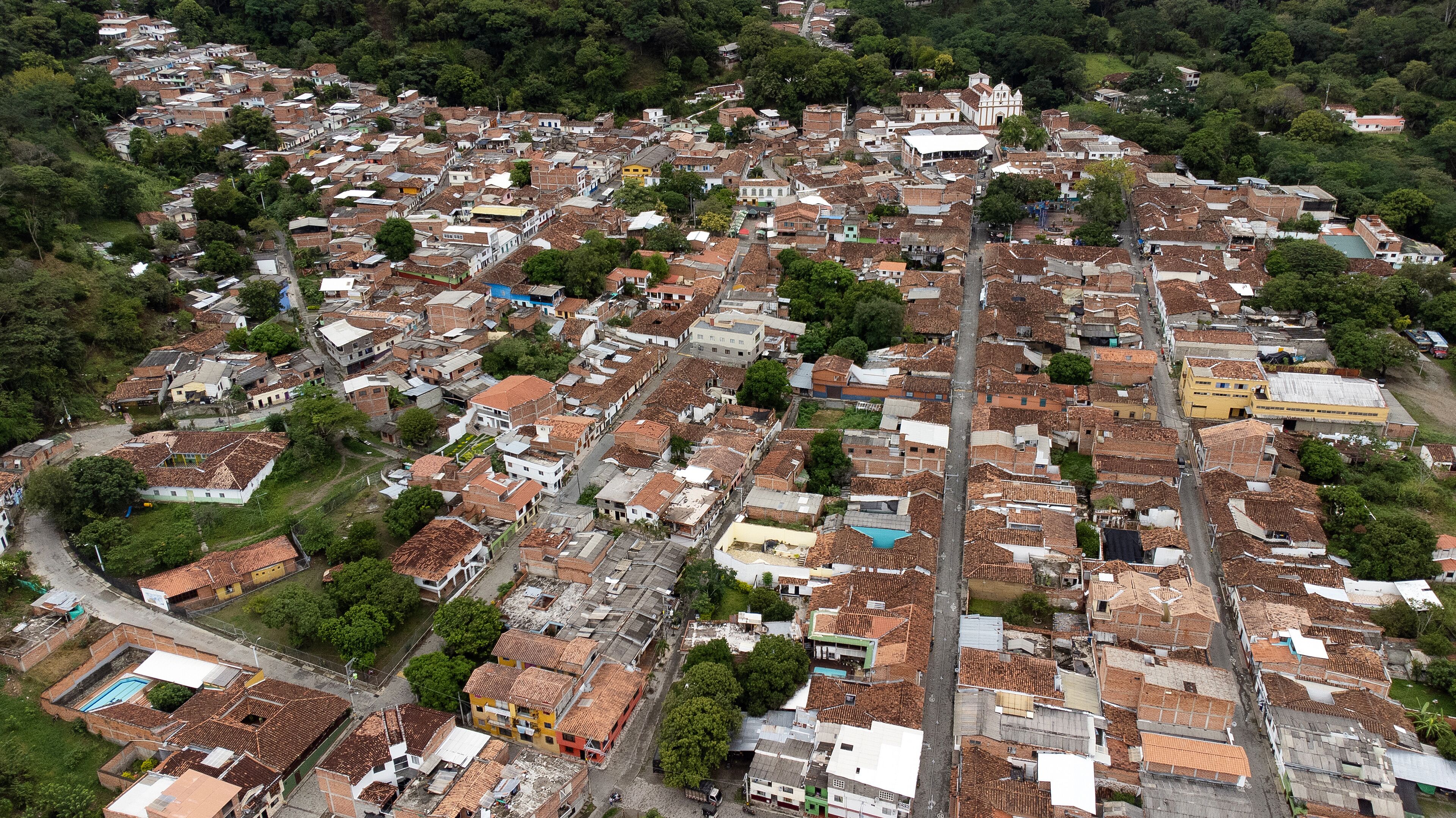 An aerial view of a densely packed urban area with numerous buildings, streets, and green spaces.