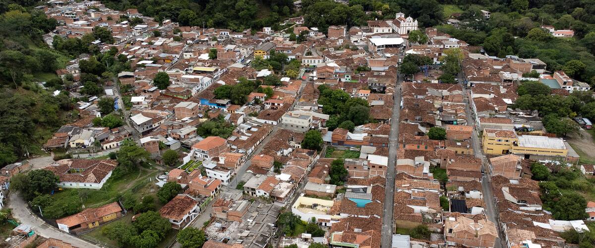 An aerial view of a densely packed urban area with numerous buildings, streets, and green spaces.