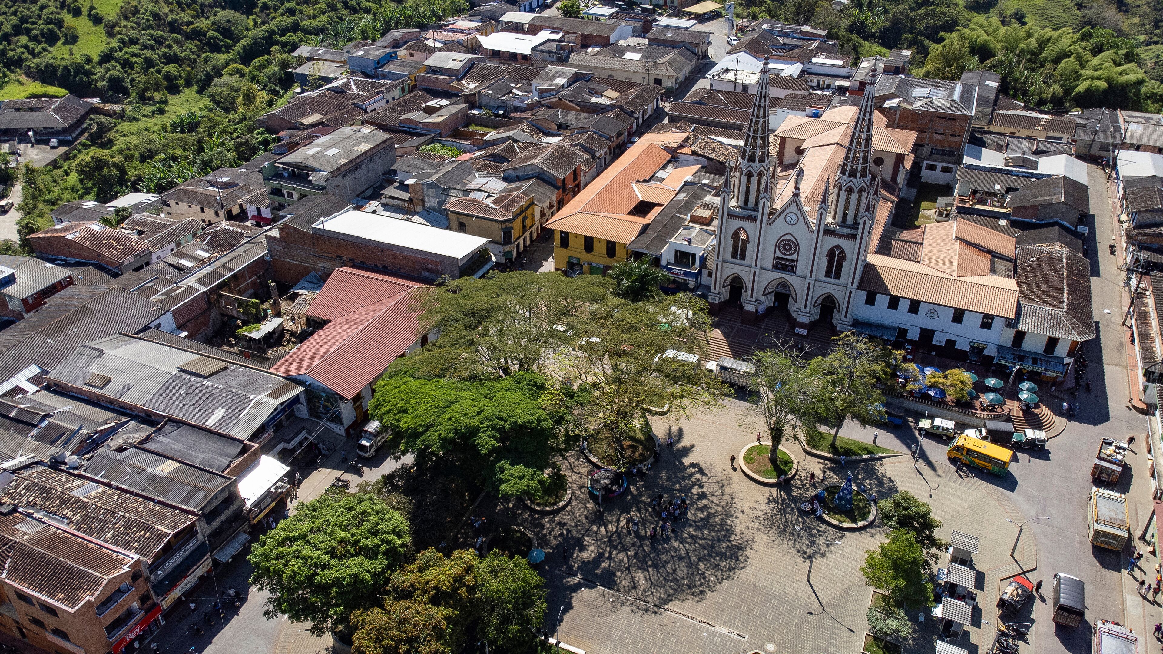 An aerial view of a town with a prominent church, a central plaza, and surrounding buildings.