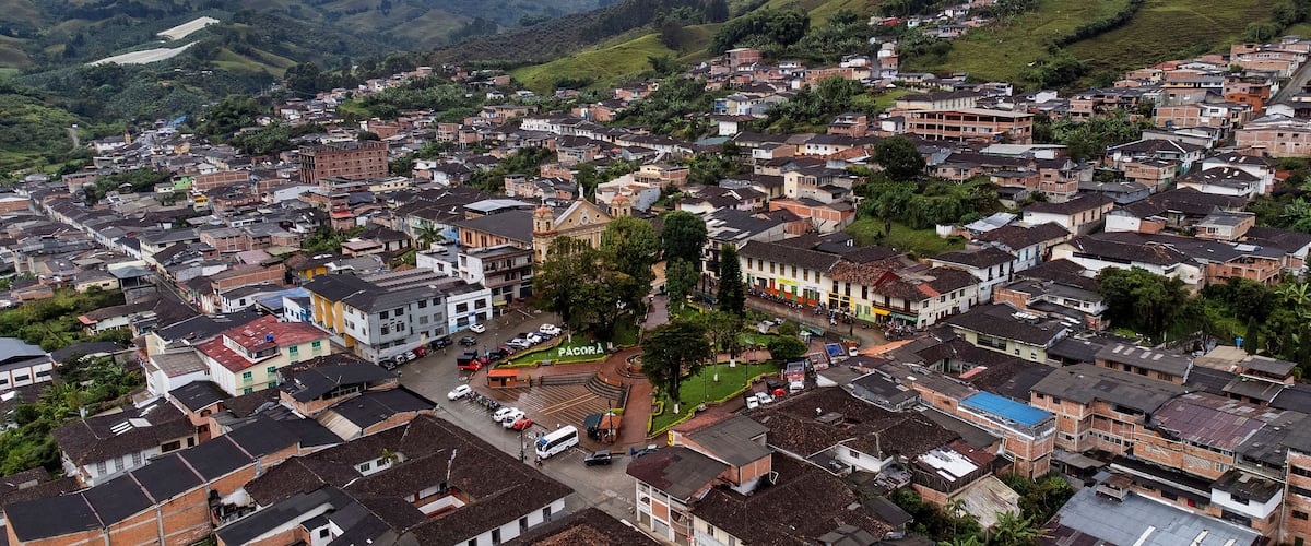 A densely packed hillside town with a prominent church and a mix of residential buildings.