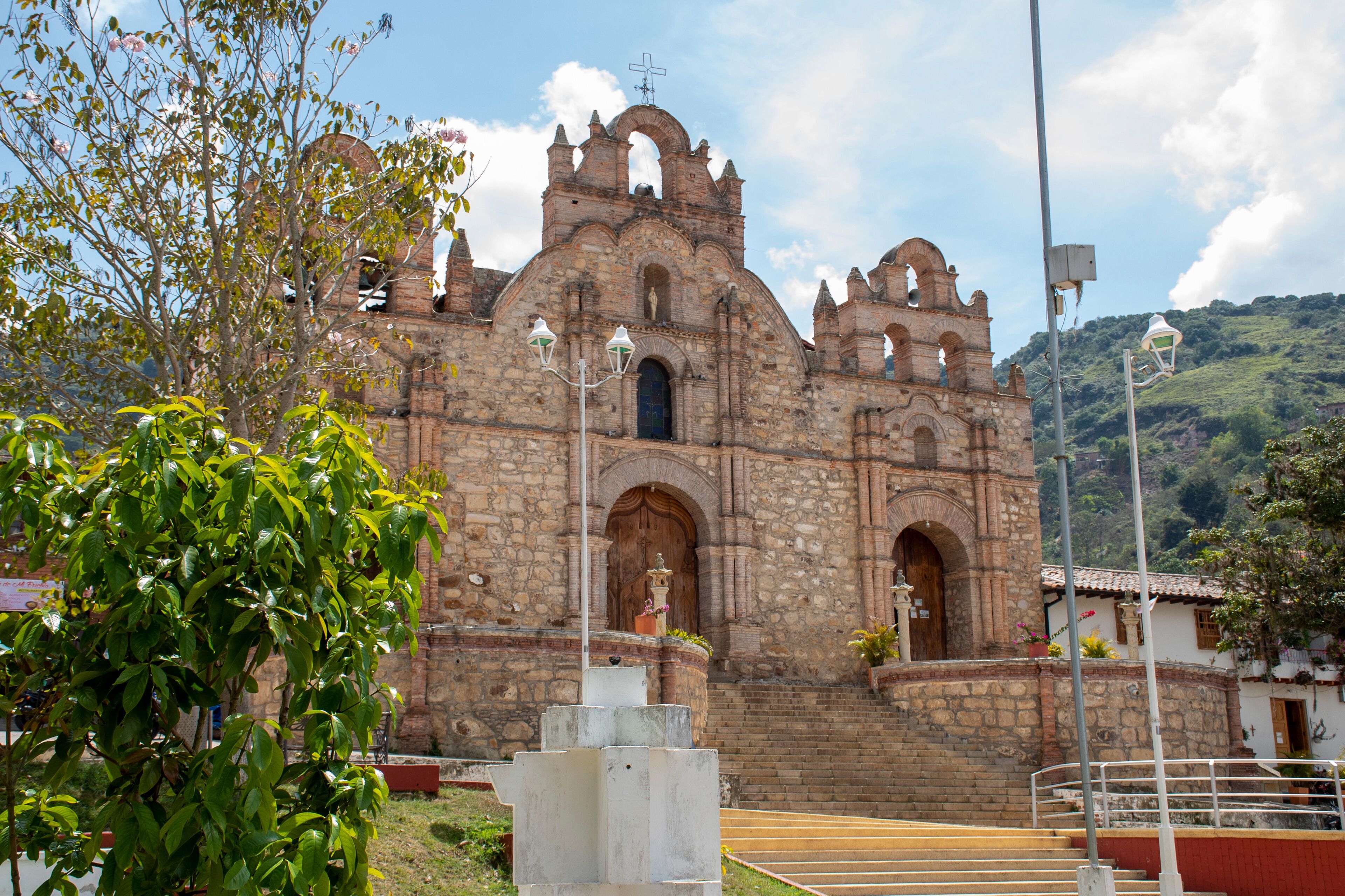 A historic stone church with arched doorways and a bell tower.