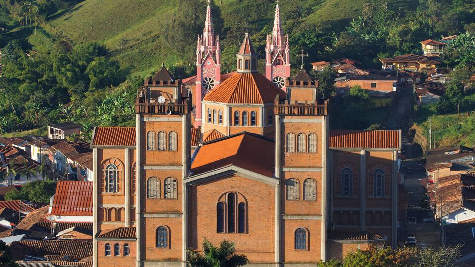 View on the Majestic red-brick "Our Lady of the Mercedes Cathedral" (Nuestra Señora de Las Mercedes Cathedral) with a pink church behind in the touristic town of Jericó, antiquia, Colombia.