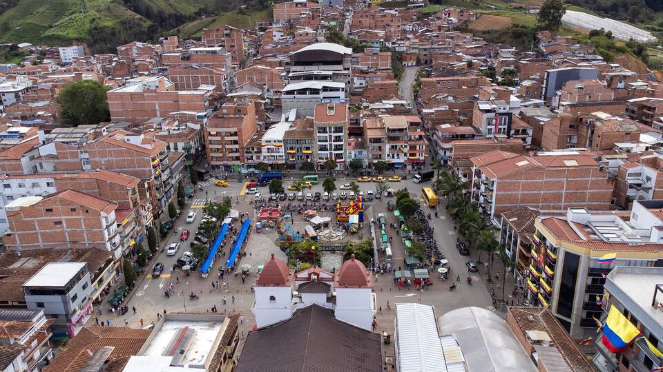 A densely packed urban area with a central plaza surrounded by buildings with red-tiled roofs.
