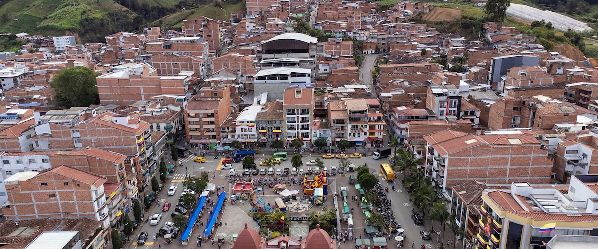 A densely packed urban area with a central plaza surrounded by buildings with red-tiled roofs.