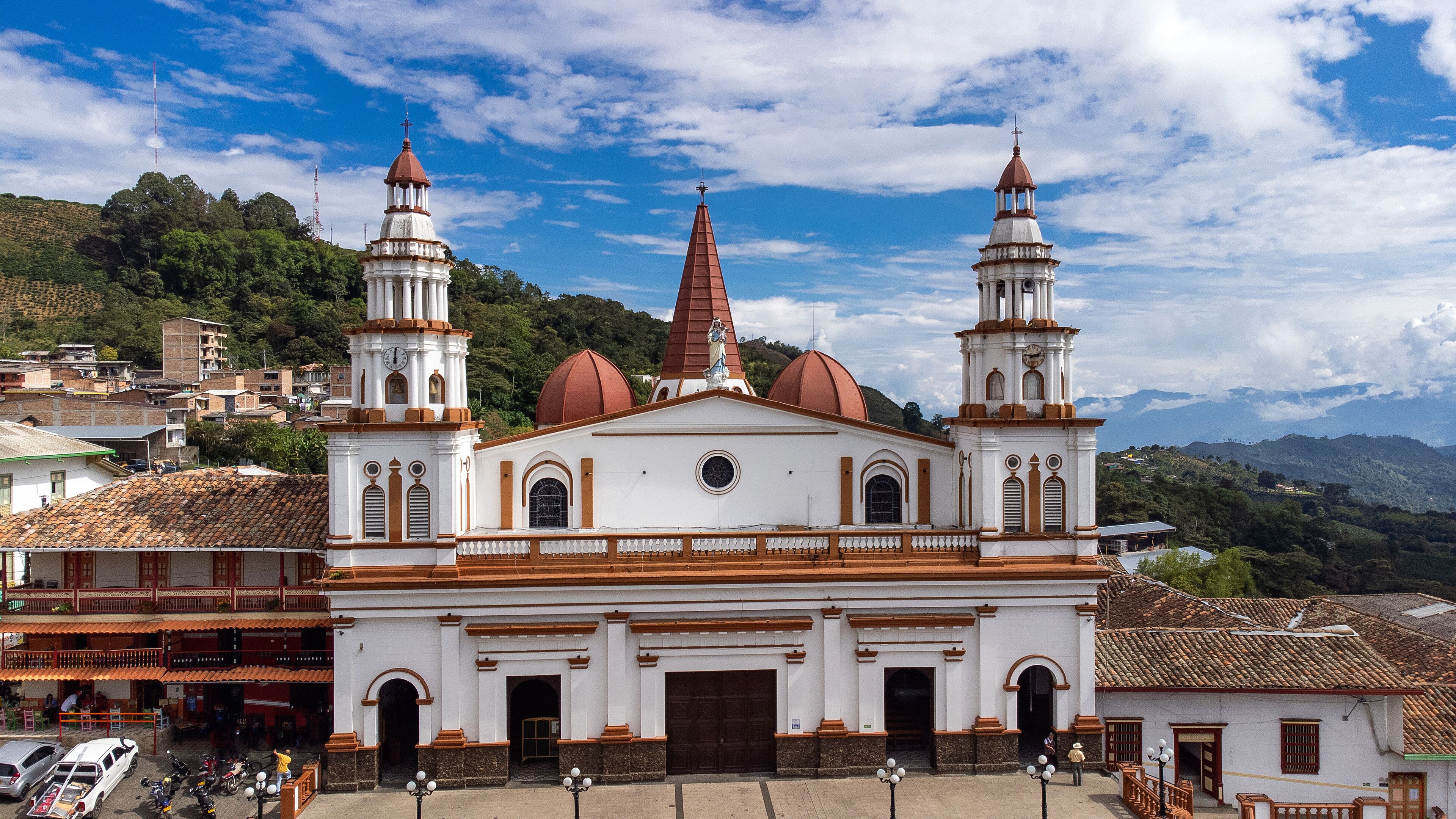 A white church with two towers and a red spire.