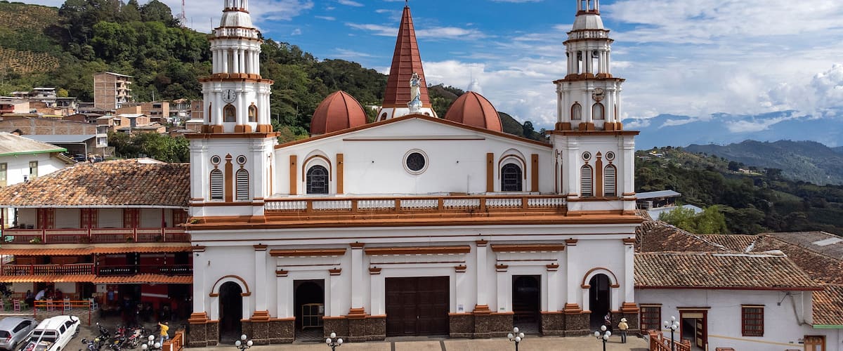 A white church with two towers and a red spire.