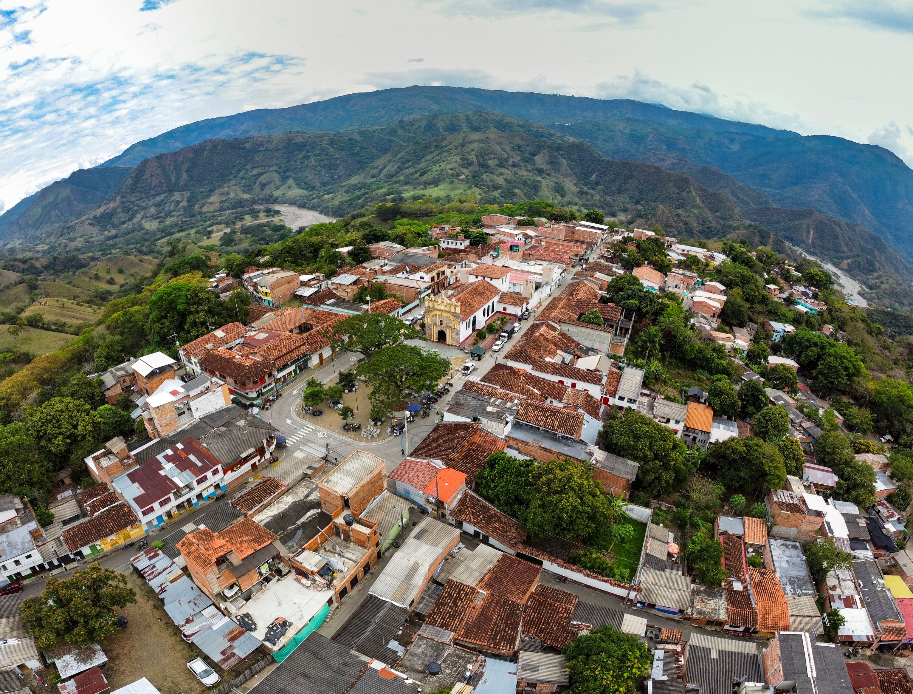 A town nestled in a valley with terraced fields and a prominent church.
