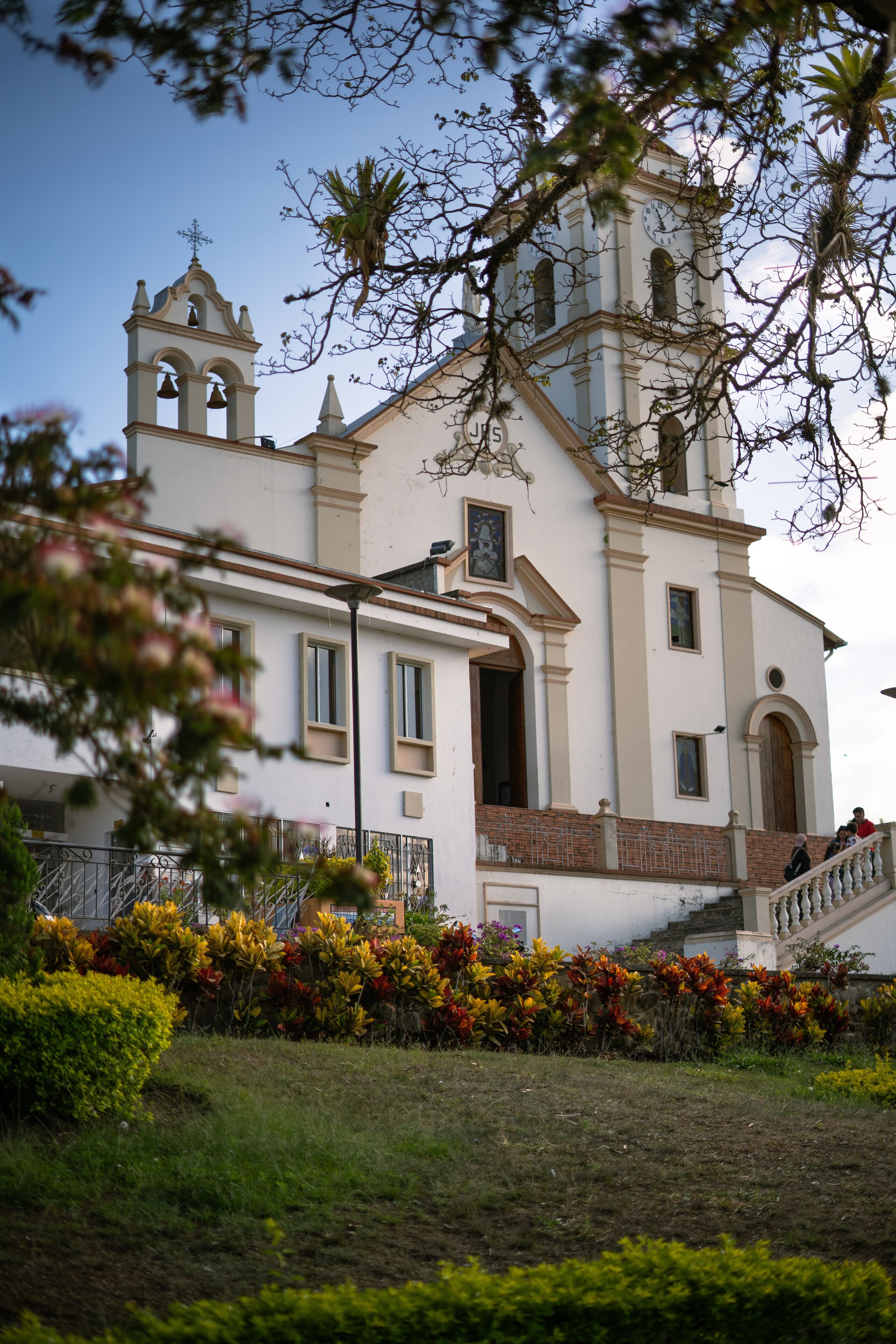 A white church with a bell tower and a staircase.