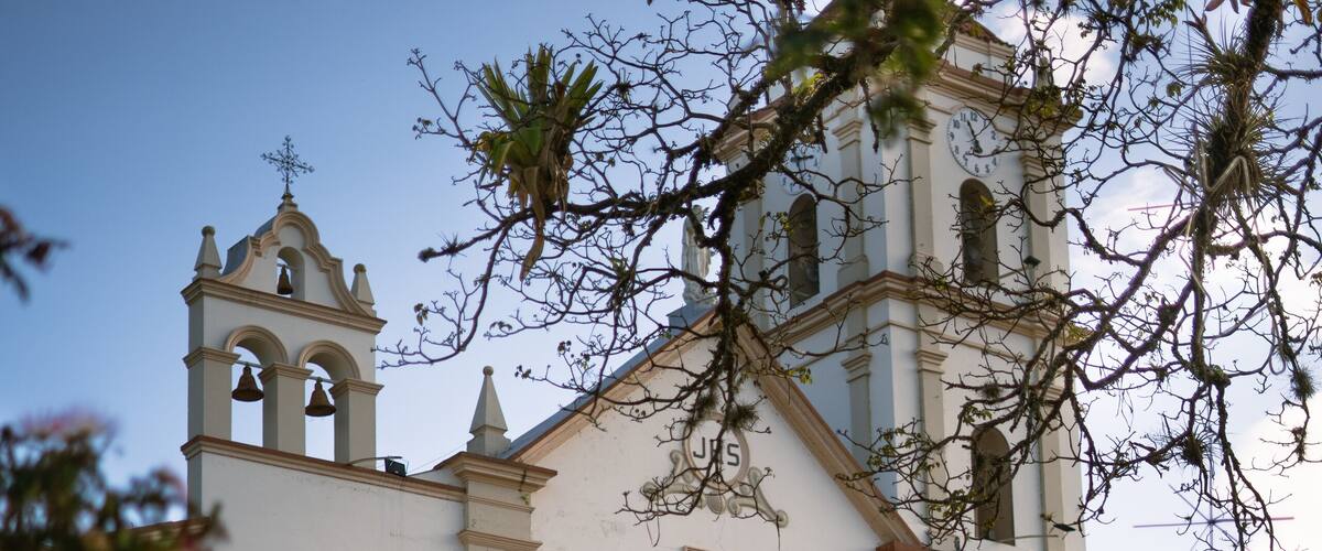 A white church with a bell tower and a staircase.