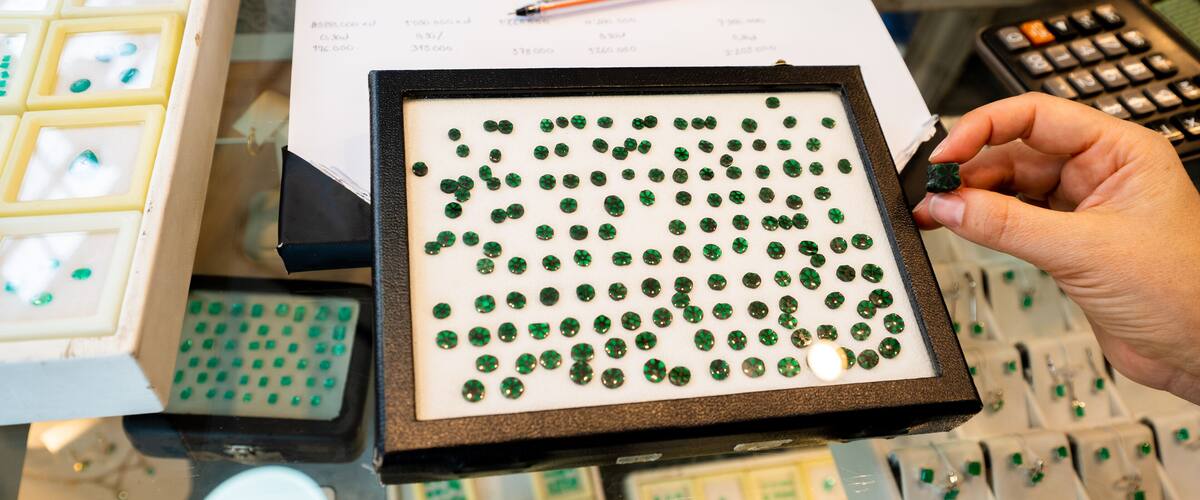 A jewelry display with various gemstones and a calculator.