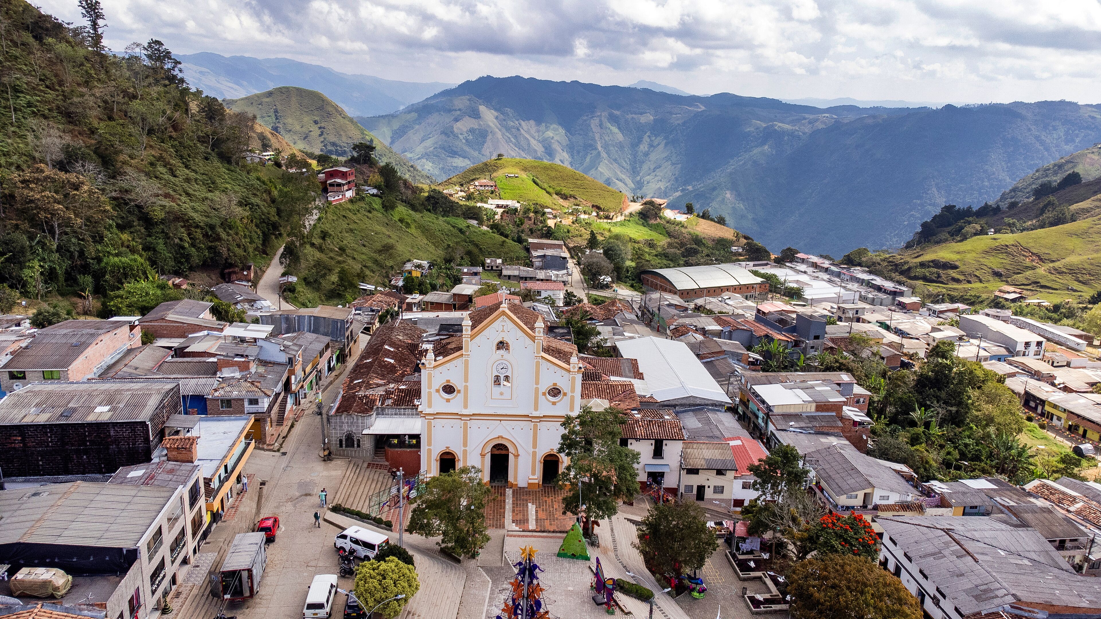 A town with a prominent church, surrounded by hills and mountains.