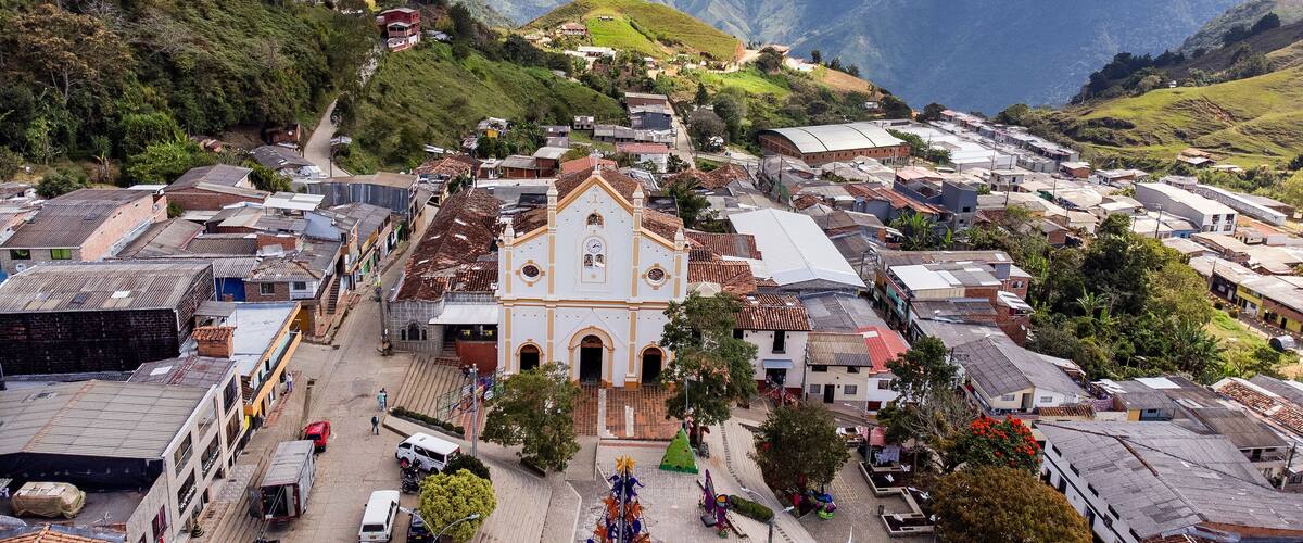 A town with a prominent church, surrounded by hills and mountains.