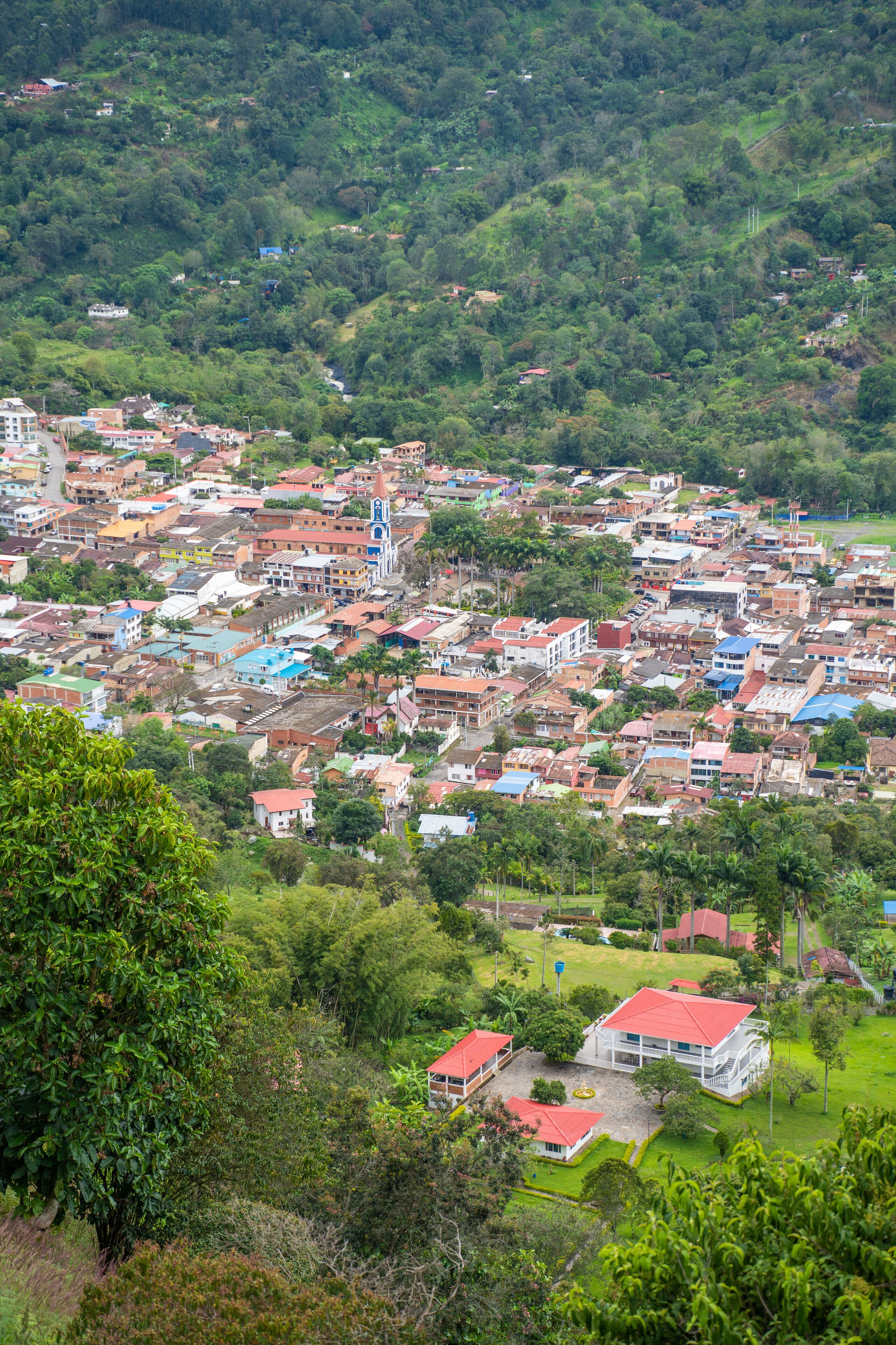A densely populated town with colorful buildings nestled in a lush green valley.