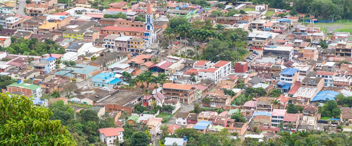 A densely populated town with colorful buildings nestled in a lush green valley.
