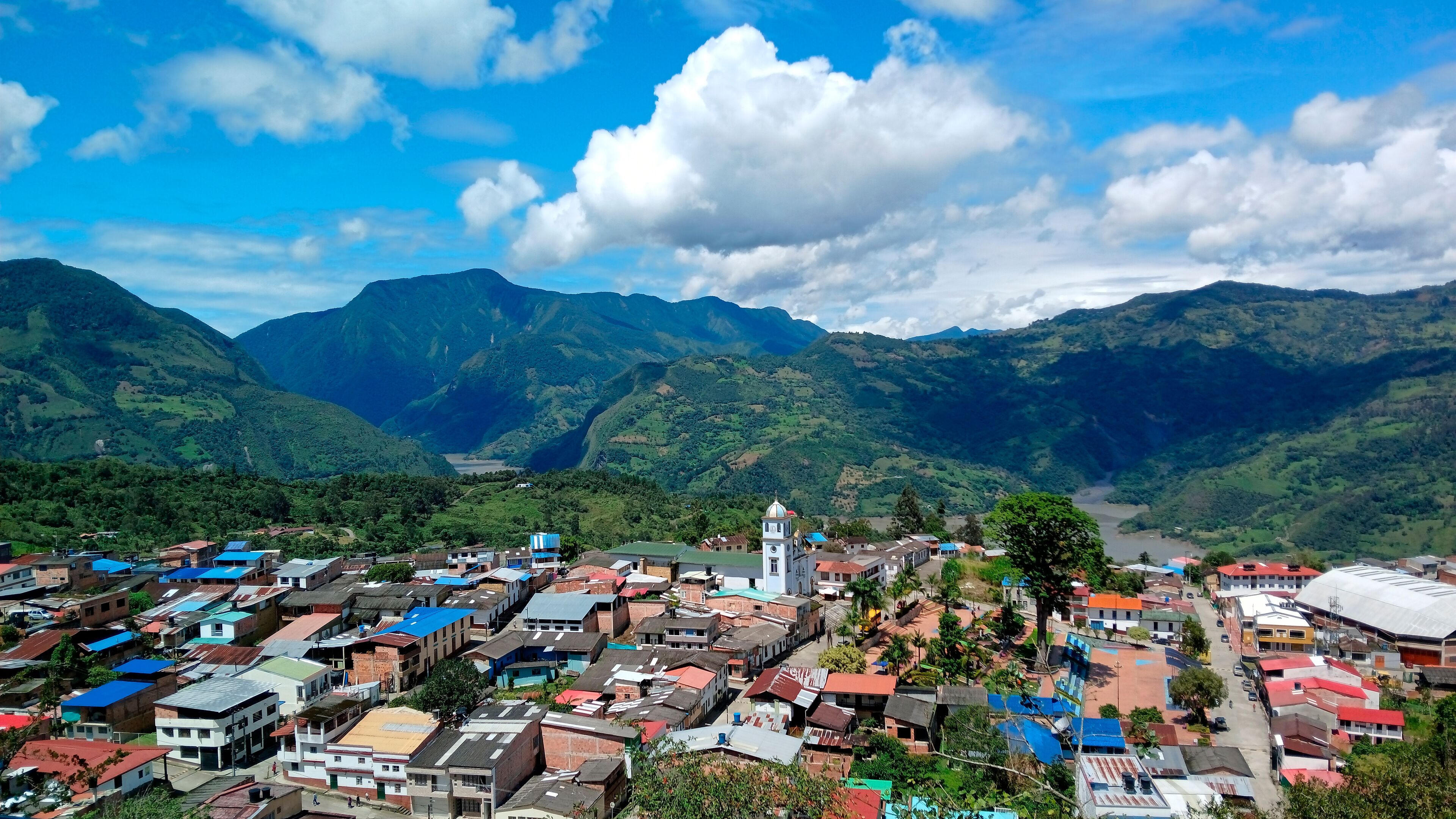 A town nestled in a valley with mountains in the background.
