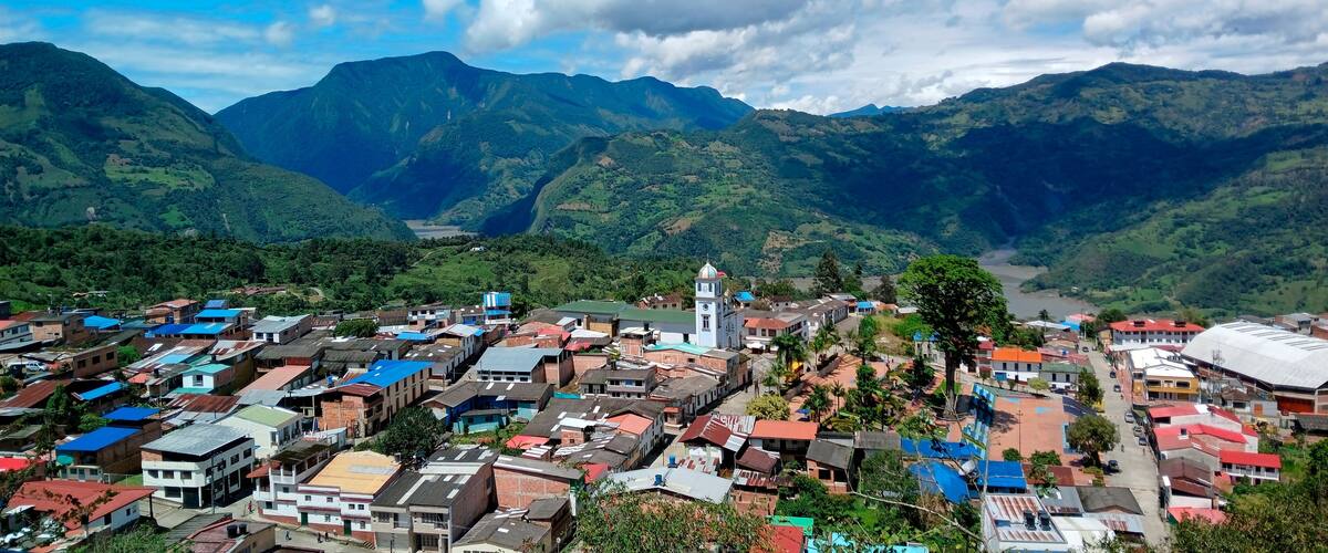 A town nestled in a valley with mountains in the background.