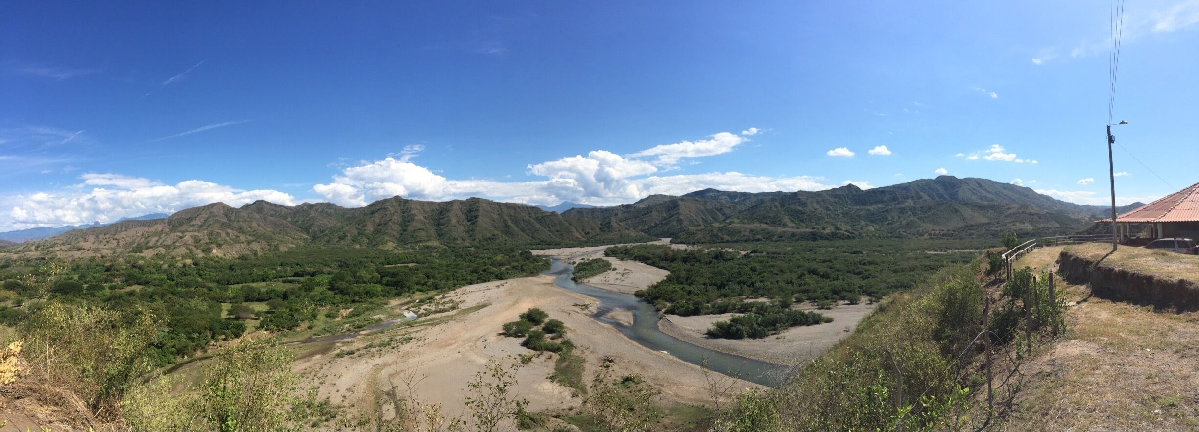 A river winding through a mountainous landscape with a clear blue sky.