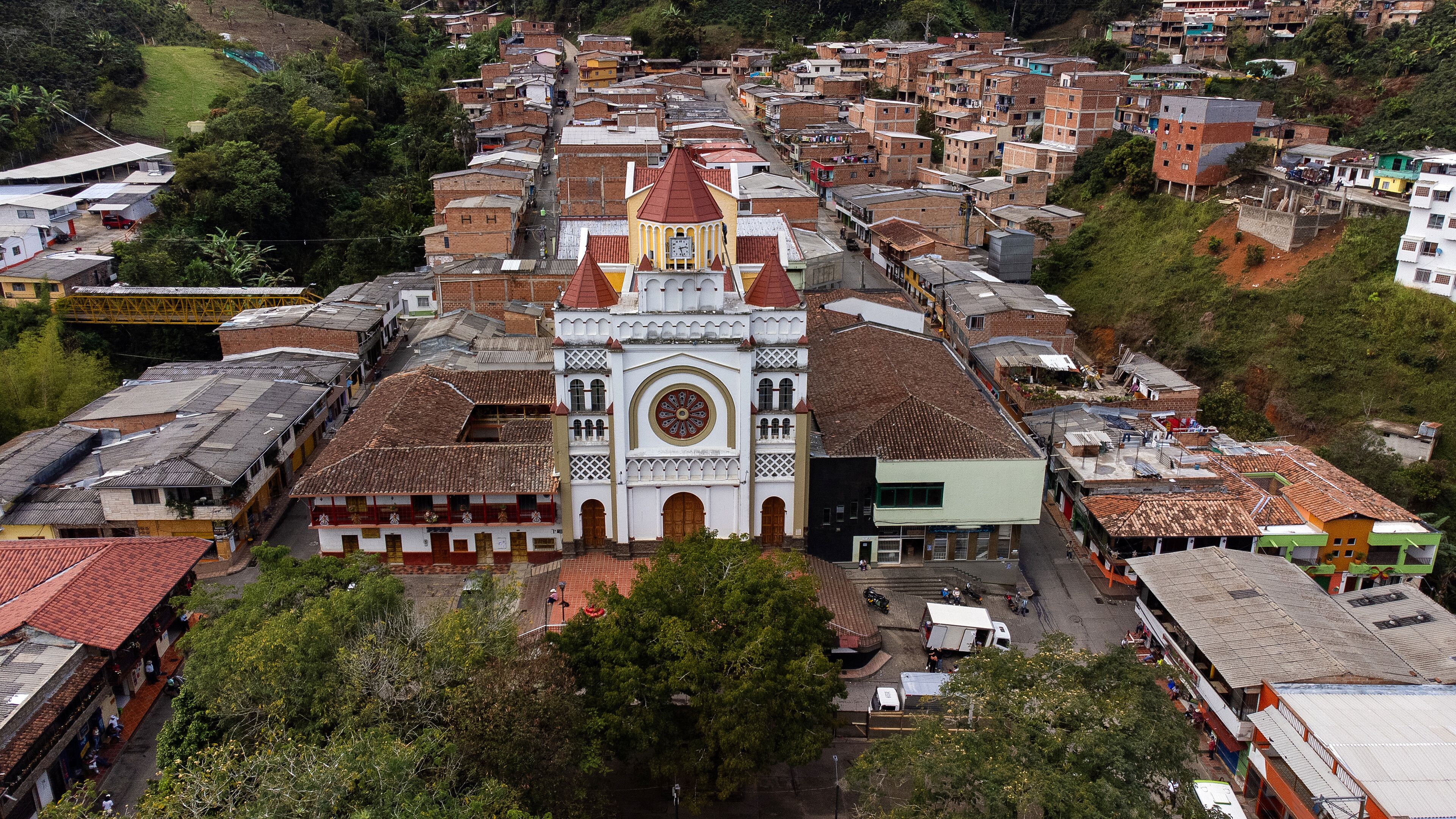 A town with a prominent church featuring a large circular window and a bell tower.