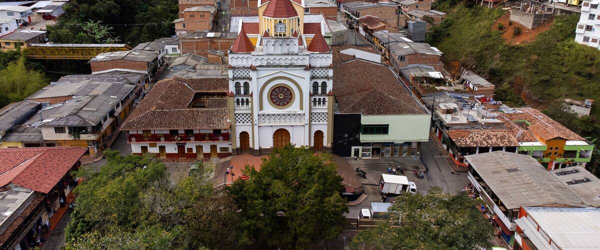 A town with a prominent church featuring a large circular window and a bell tower.