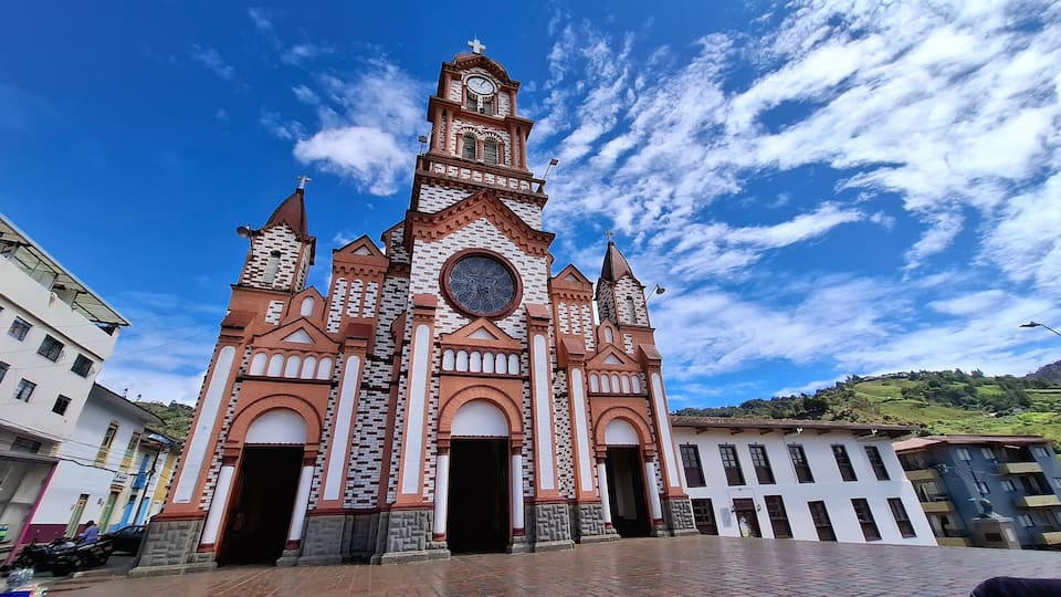 A church with a clock tower and a large circular window.