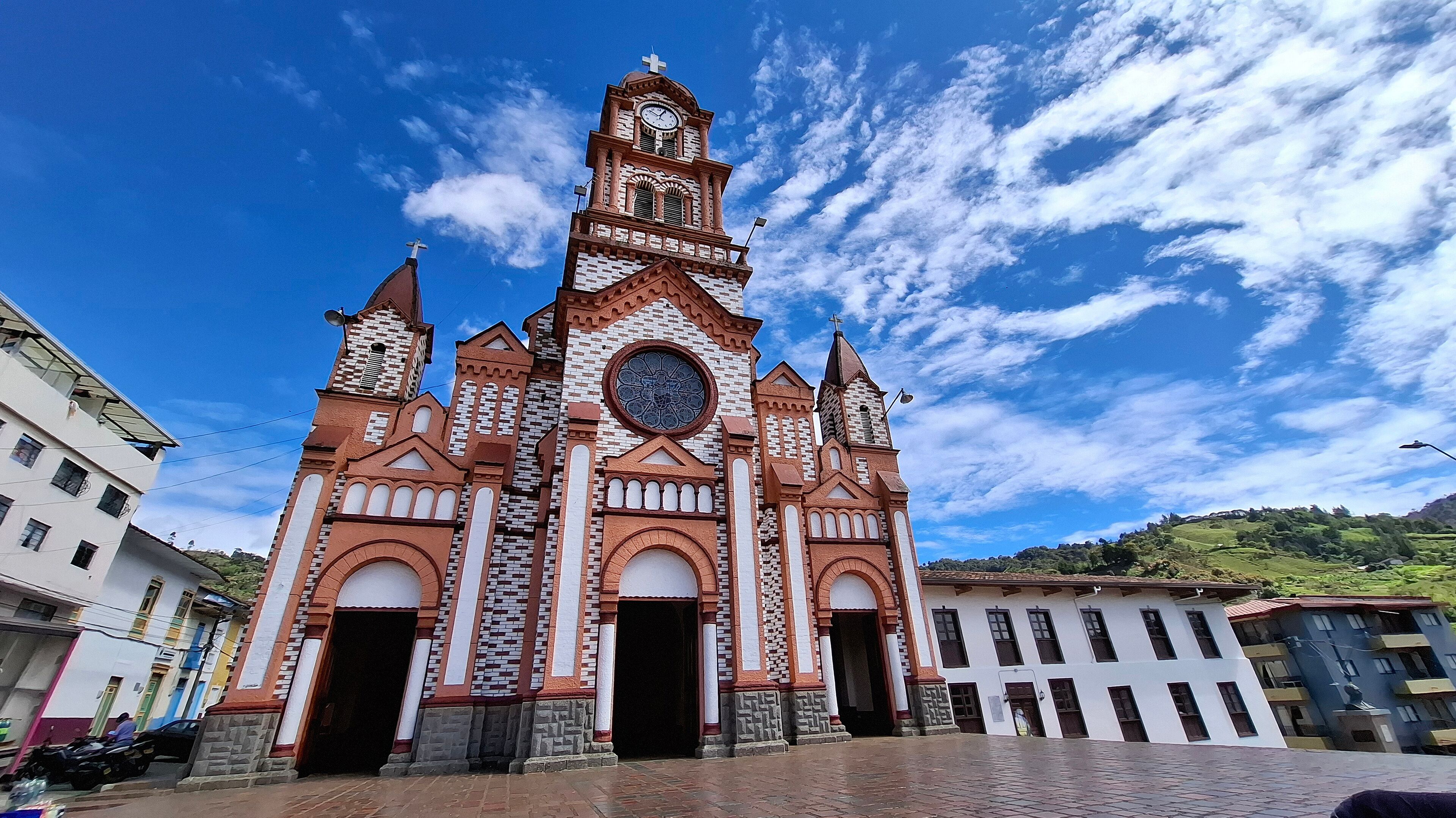 A church with a clock tower and a large circular window.