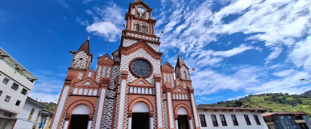 A church with a clock tower and a large circular window.