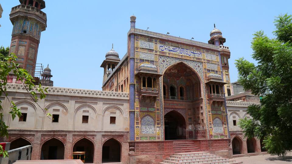 A historic building with intricate tile work and multiple domes.