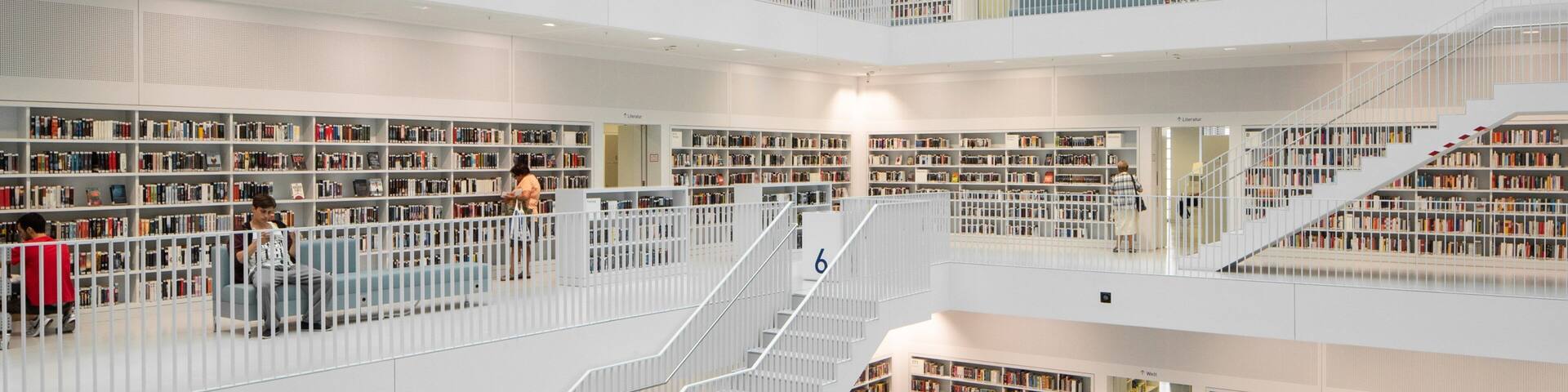 A multi-level library with bookshelves and a central staircase.