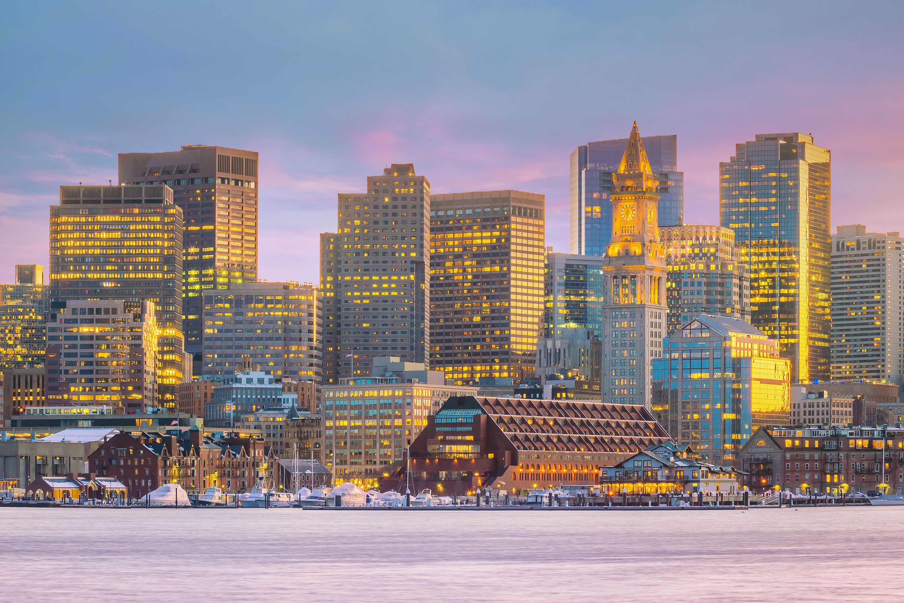 A city skyline with illuminated buildings and a prominent clock tower.