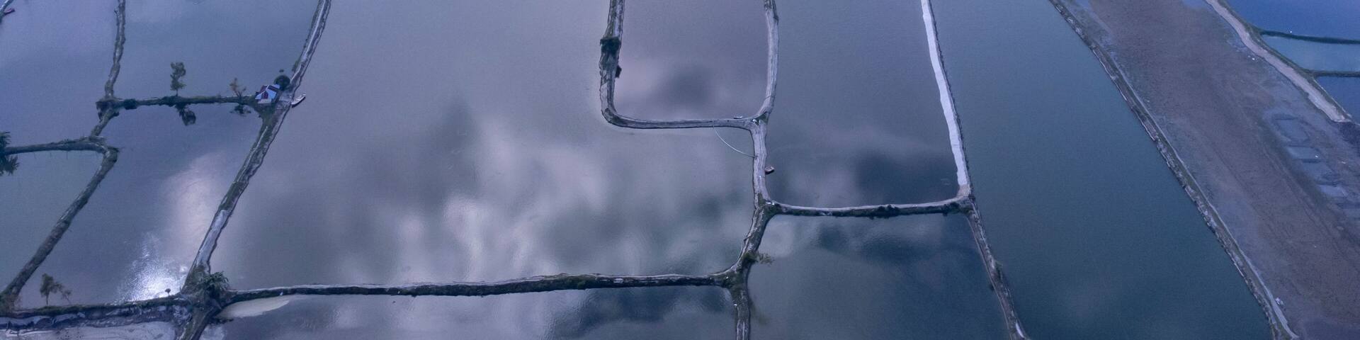 Flooded rice paddies from an aerial perspective creating geometric patterns. The Muhuri Project is Bangladesh's second-largest irrigation project. Aerial View of Farm Ponds and Coastal Landscape