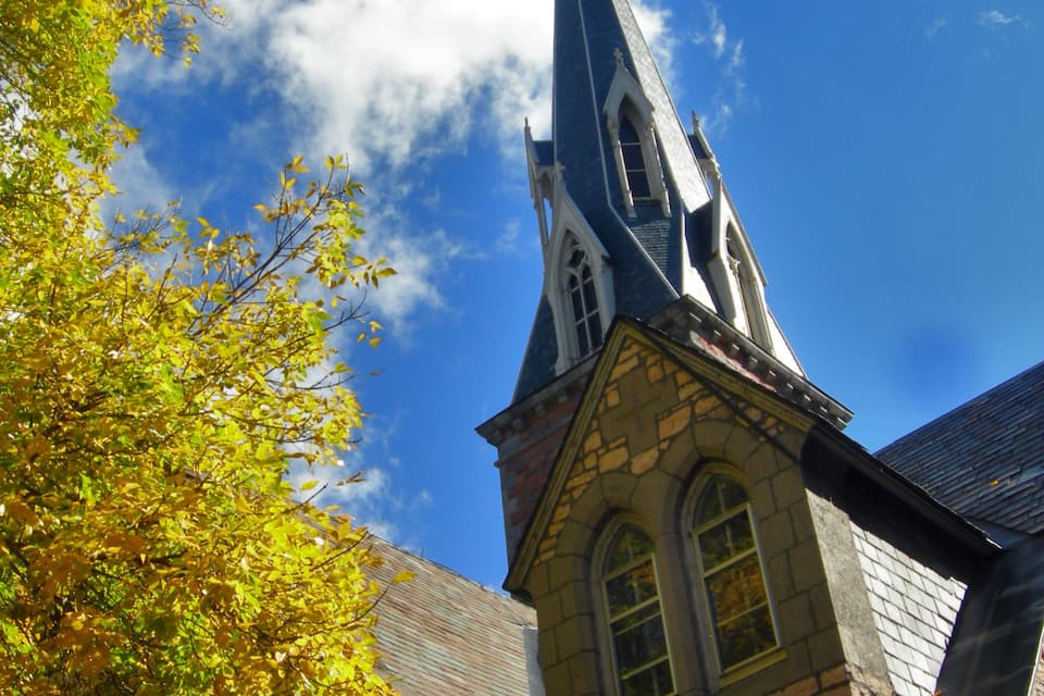 Una iglesia con un campanario alto y fachada de piedra.