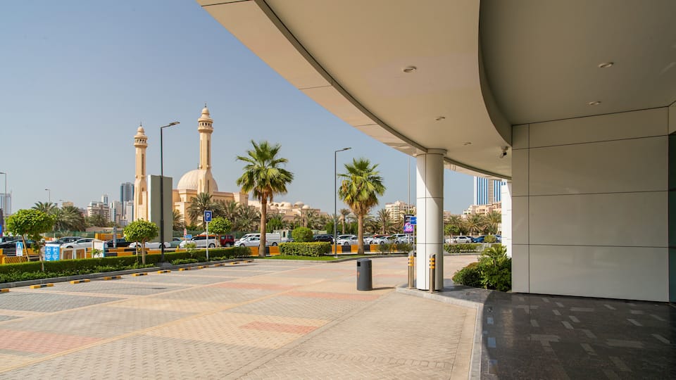Une vue urbaine comprenant une mosquée, des palmiers et des bâtiments modernes.