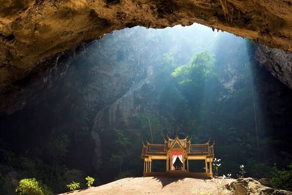 Morning sunbeam on golden buddhist pavilion in wild cave, Sam Roi Yot, Thailand