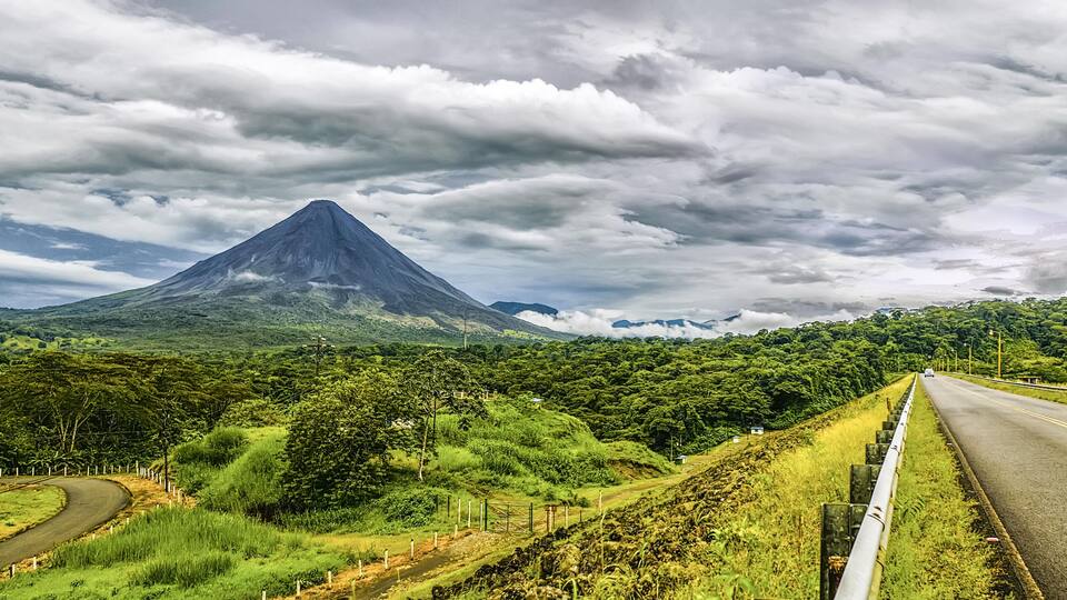 A winding road with a mountain in the background.