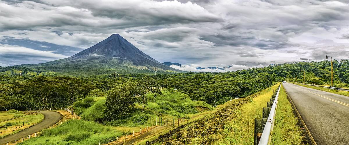 A winding road with a mountain in the background.