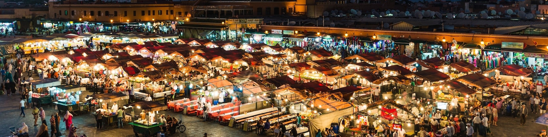 A bustling nighttime market with numerous stalls and people.