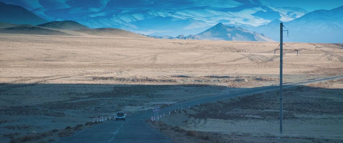 A road leading towards a mountain range.
