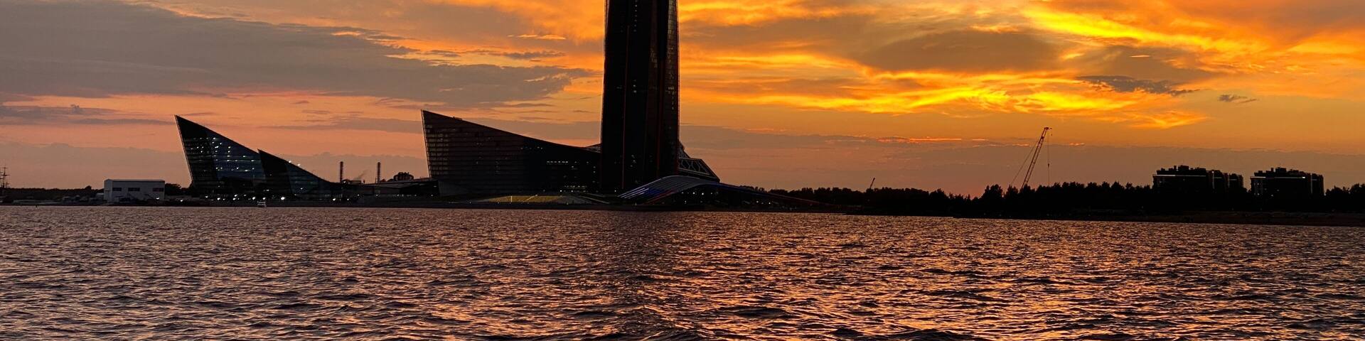 View from the yacht of the Gulf of Finland and the Lakhta Center skyscraper on the background of a pink sunset, the coastline,the tallest building in Europe.Russia,Saint Petersburg,14.04.2022