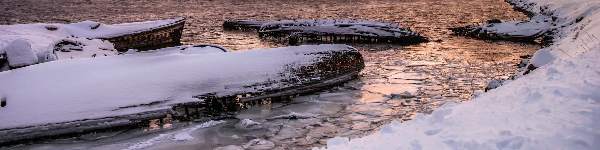 Sunken ships near the snowy coast in Teriberka, Murmansk Region, Russia