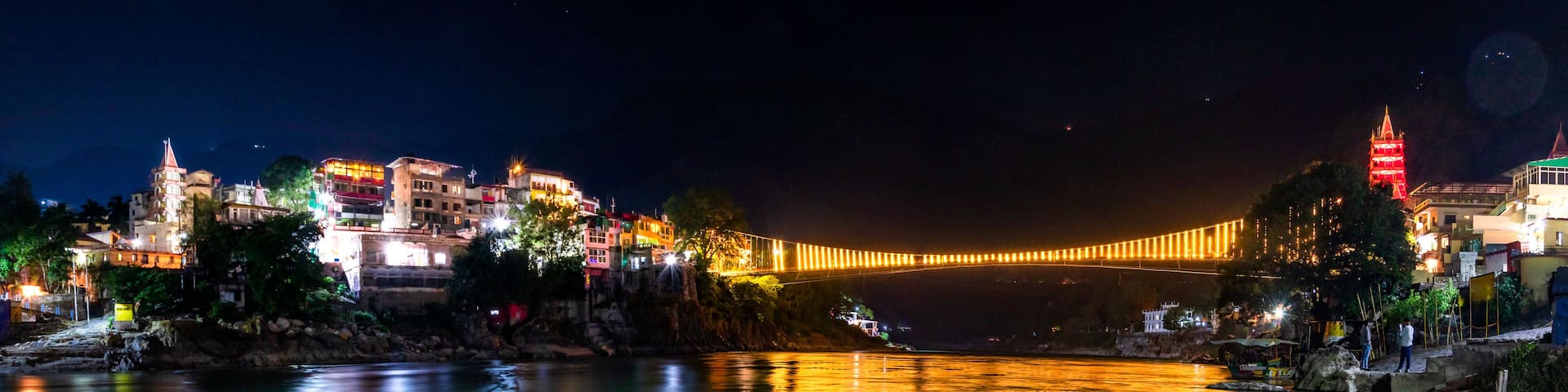 Spectacular illuminated panoramic cityscape of Rishikesh, the yoga capital of World located in foothills Himalayas along banks of river Ganga or Ganges in Uttarakhand state of India.