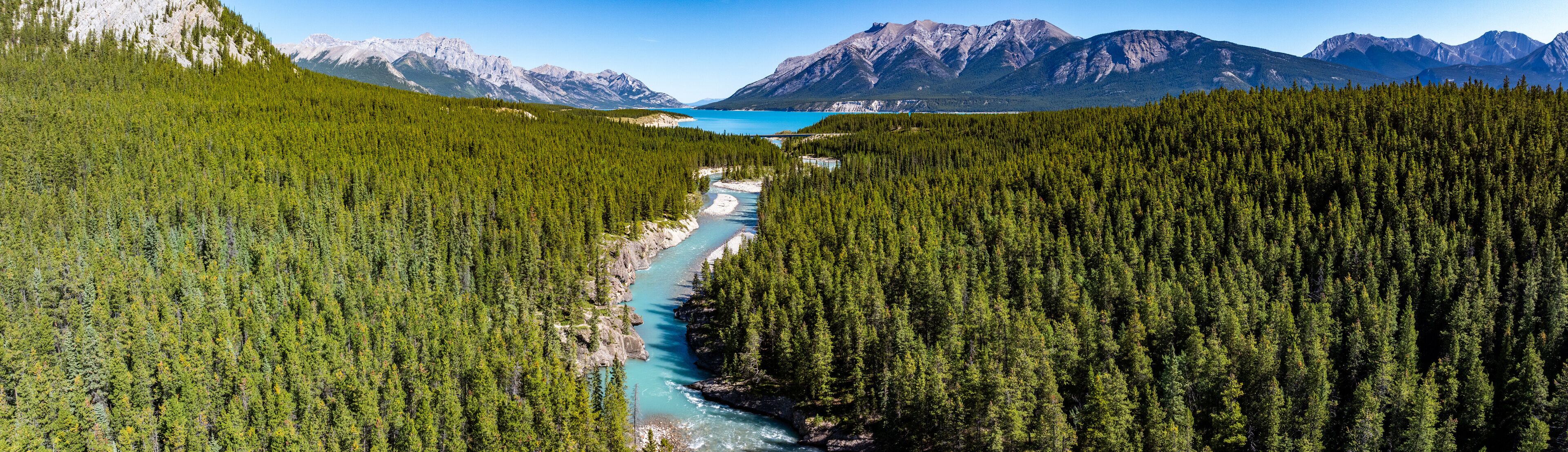 Canadian panoramic aerial landscape view along river course of Cline river with river mouth into North Saskatchewan River as well Abraham Lake and Rocky Mountains in background 