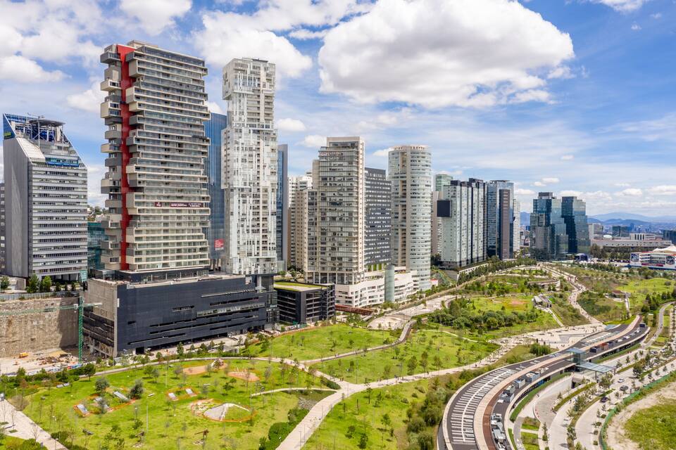Paisagem urbana com edifícios modernos e altos, área verde de um parque e uma extensa rede de ruas.