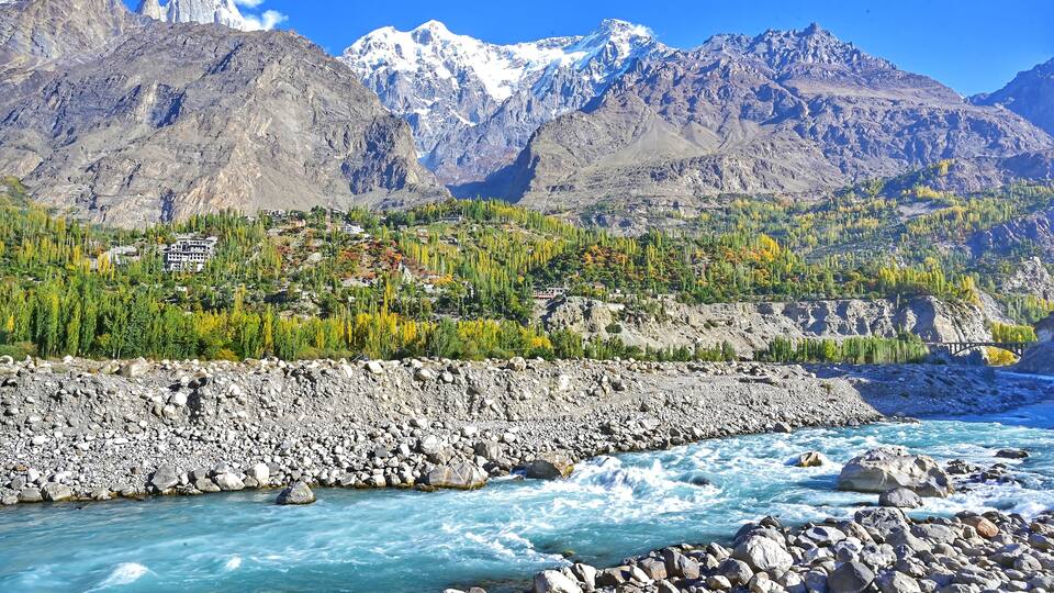 A river flowing through a rocky landscape with mountains in the background.