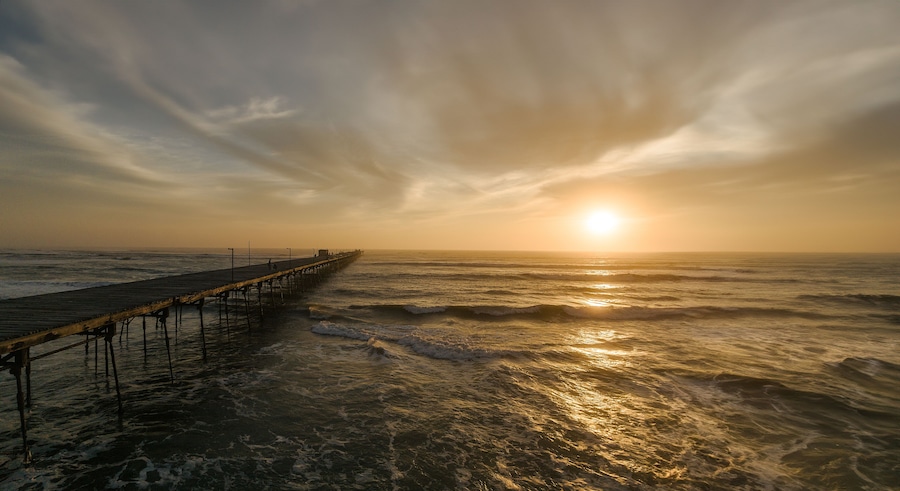 Pier in the ocean on a colorful sunset. Puerto Eten.