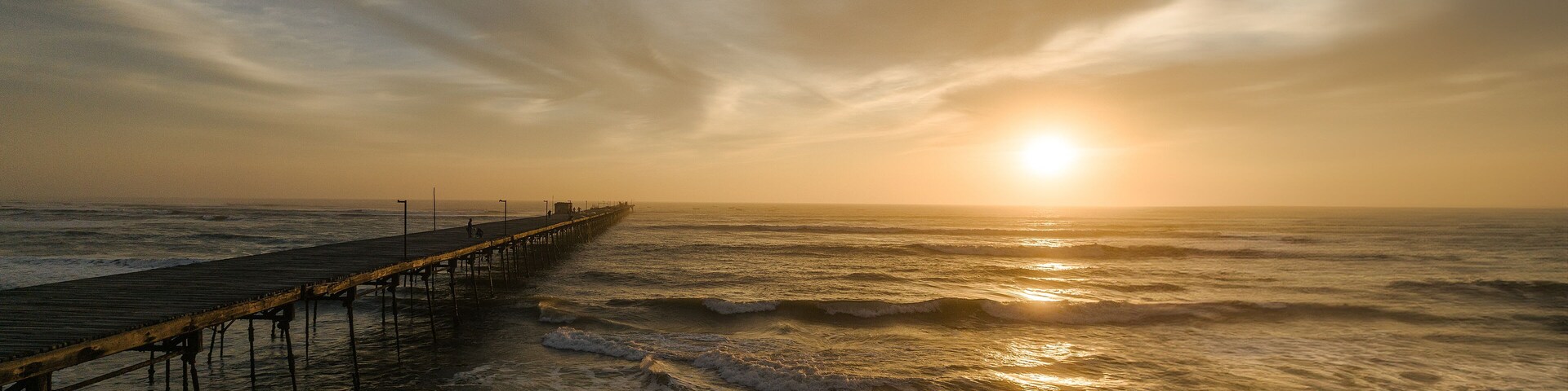 Pier in the ocean on a colorful sunset. Puerto Eten.