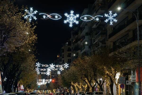 Thessaloniki, Greece night view of Christmas holidays decorations above a main road. Festive instalments of illuminated hanging lit stars at Tsimiski street with less traffic.