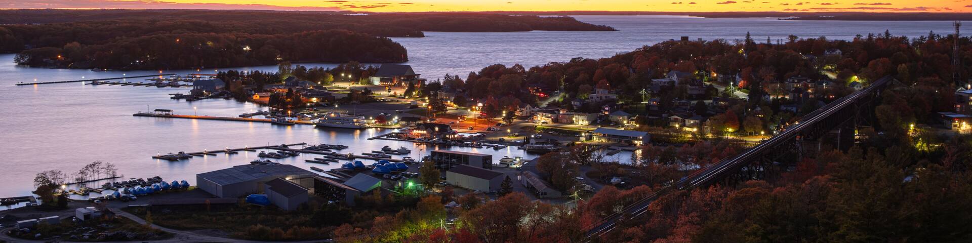Aerial view of Parry Sound, Ontario, Canada downtown and waterfront with moored sail boats, cruise ships, docks, restaurants and marinas shot at sunset time.
