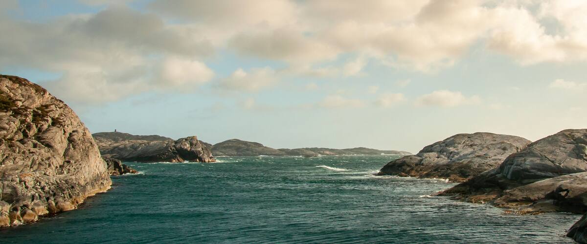 A coastal landscape with rocky formations and a body of water.